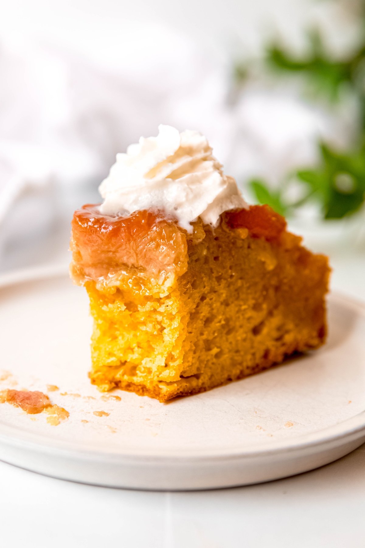 slice of apricot almond banana upside down cake with a bite taken out.
