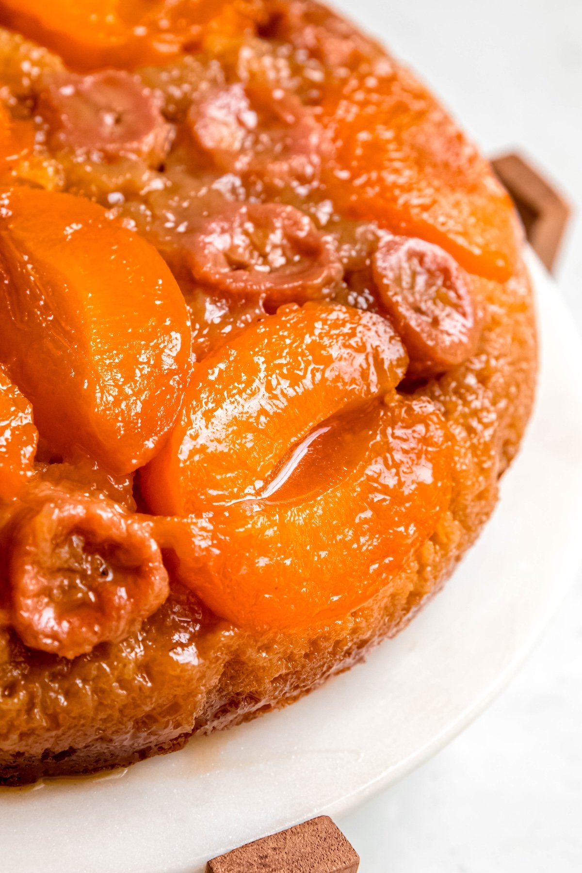 closeup shot of the right half of a cake mix banana almond apricot upside-down cake showing the shiny, caramel-coated fruit.