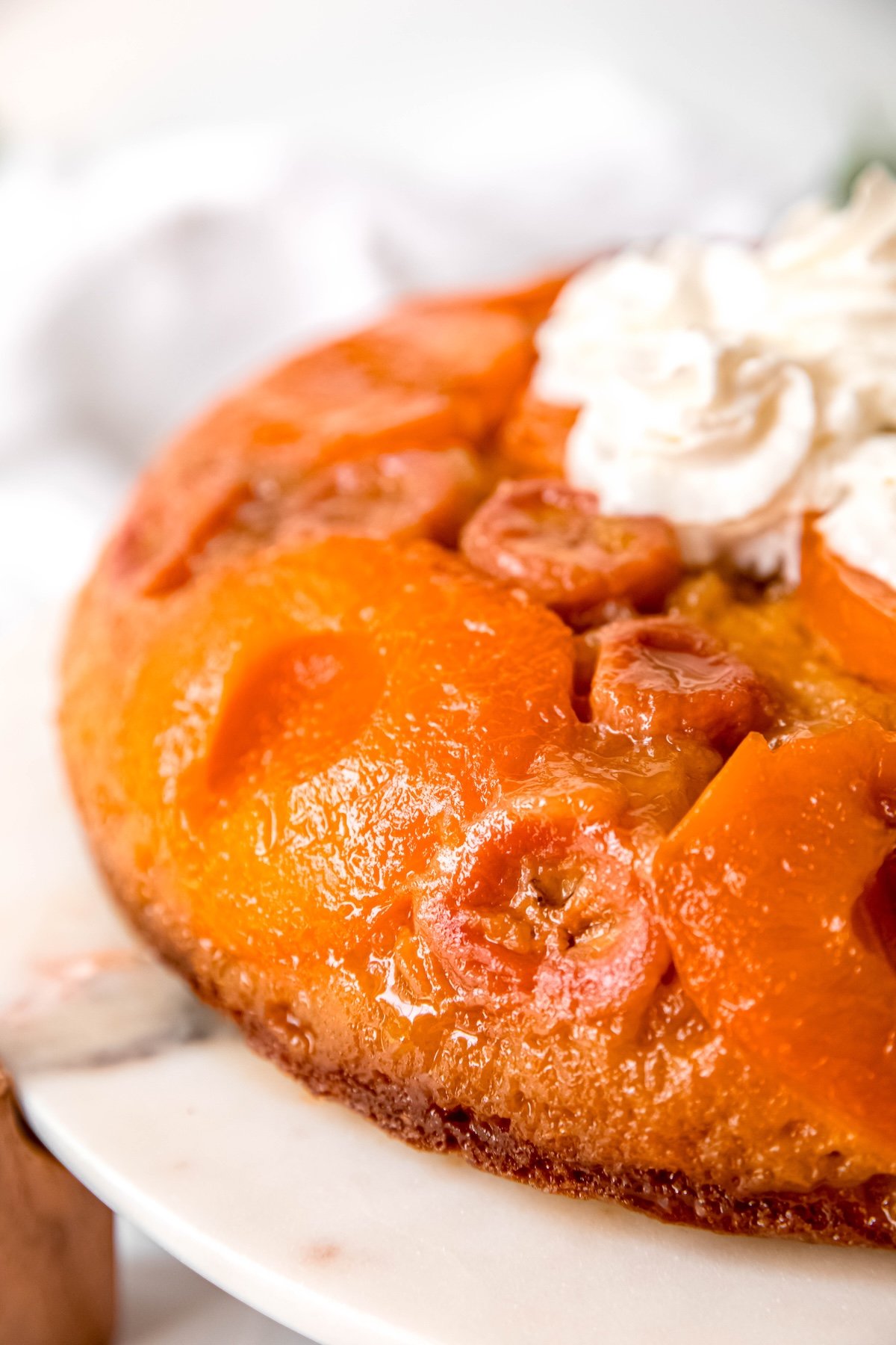 left half of a cake mix upside down cake topped with bananas, apricots, and whipped cream.