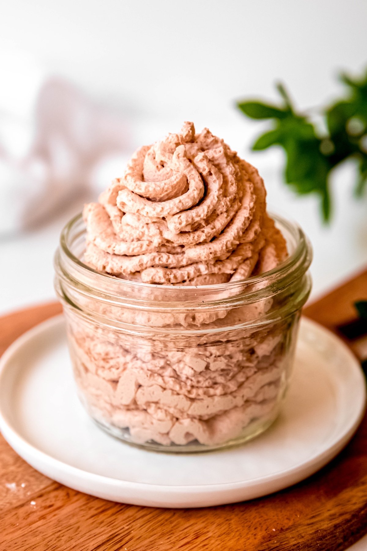 chocolate whipped cream from a dispenser piped into a short mason jar.