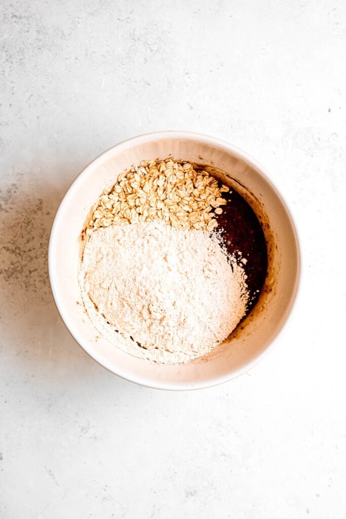 flour and oats added to the bowl with the wet ingredients.