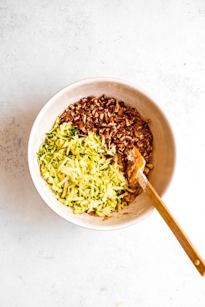 chopped pecans and shredded zucchini added to the bowl with the vegan muffin batter.