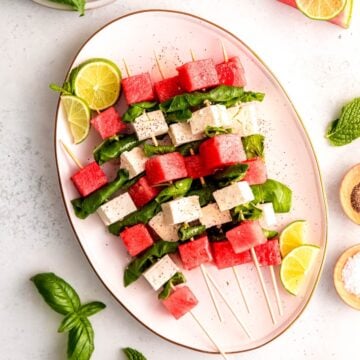 square hero image of a platter of watermelon feta mint skewers.