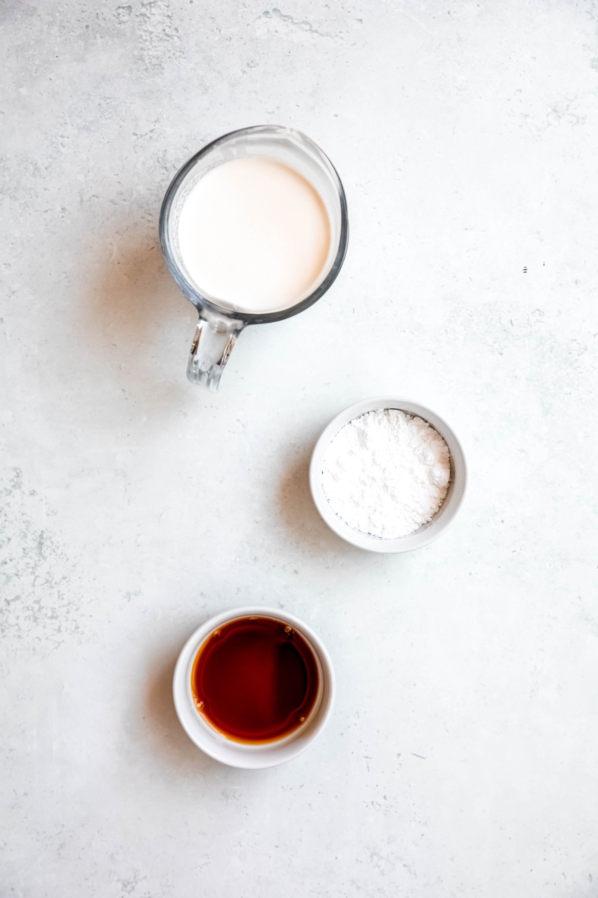 cream, powdered sugar, and vanilla measured out for making classic whipped cream in a dispenser.