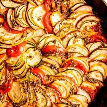 square hero closeup shot of Disney ratatouille-style confit biyaldi with shingled slices of tomatoes, eggplant, zucchini, and summer squash.