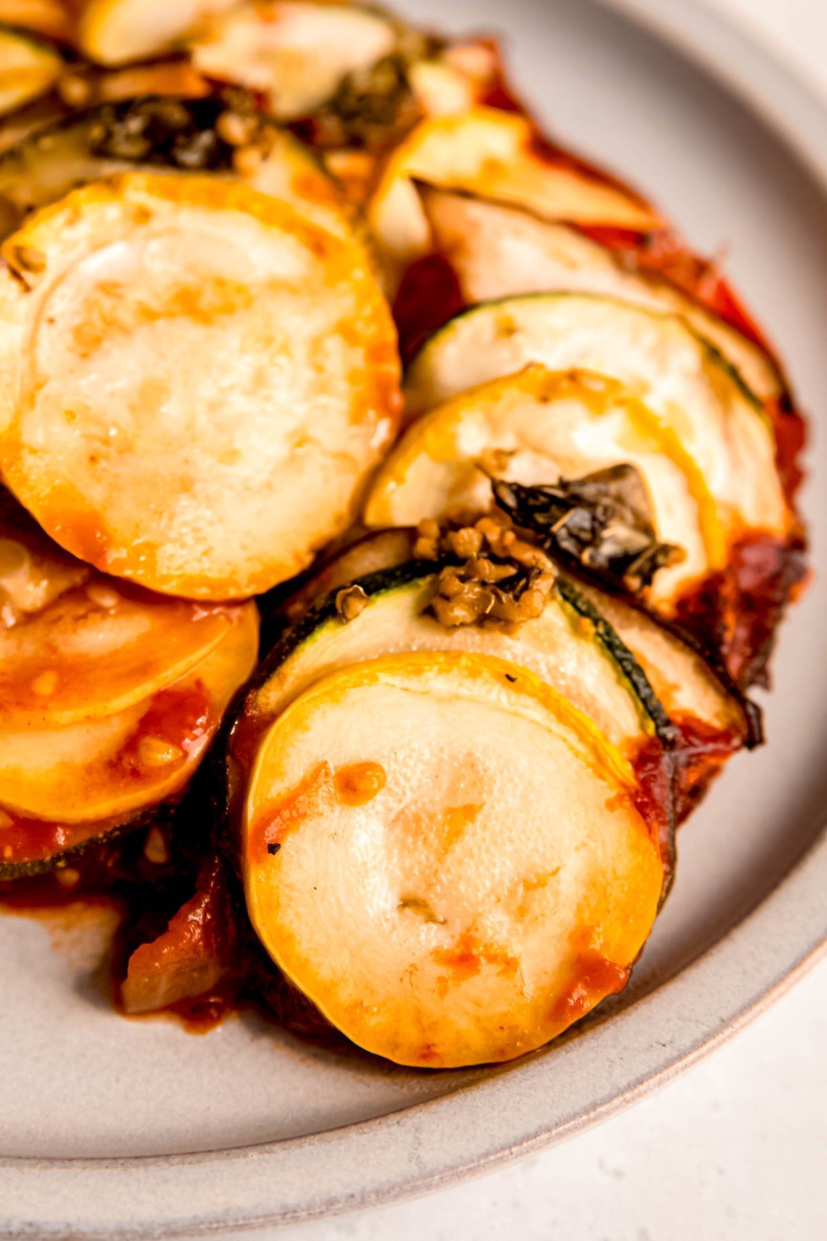 serving of fancy shingled ratatouille on a white serving plate.