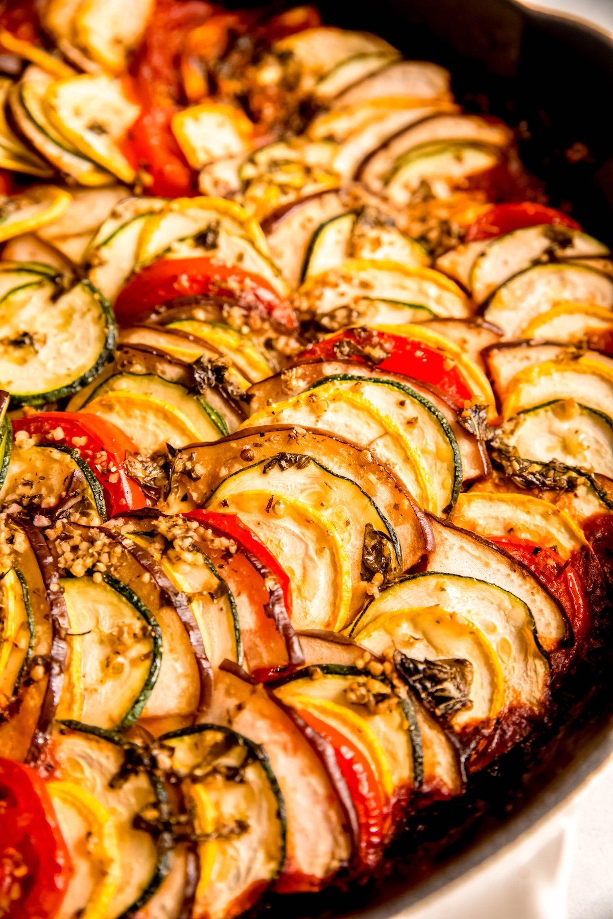 angled closeup shot of ratatouille tian in a skillet after baking.