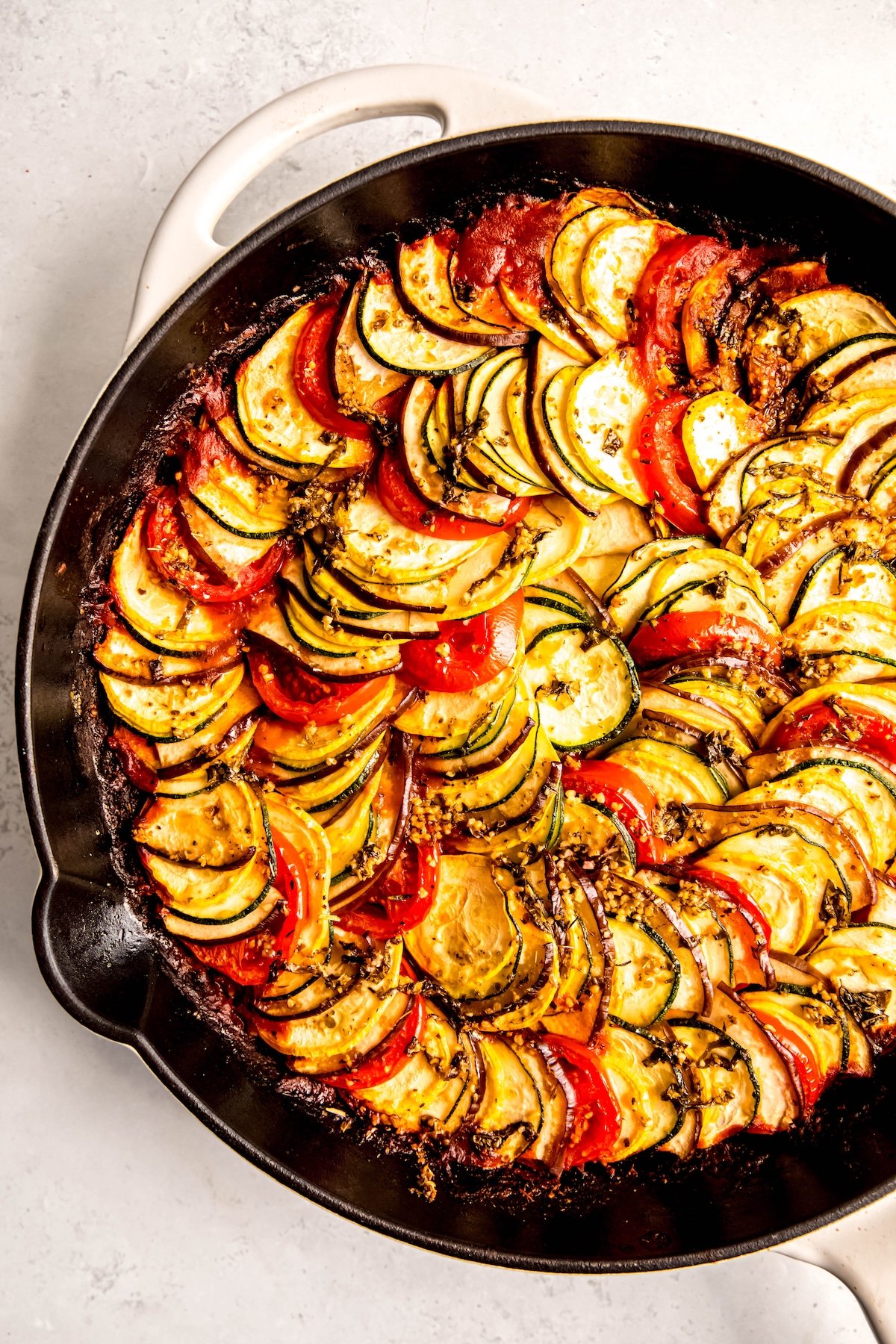 white enameled cast iron skillet filled with homemade remy's ratatouille from Disney's ratatouille movie.