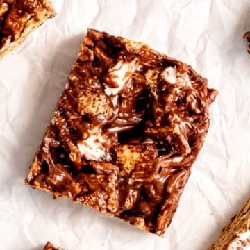 closeup overhead shot of a s'mores cereal bar on a parchment sheet with a few others on the outsides of the frame.