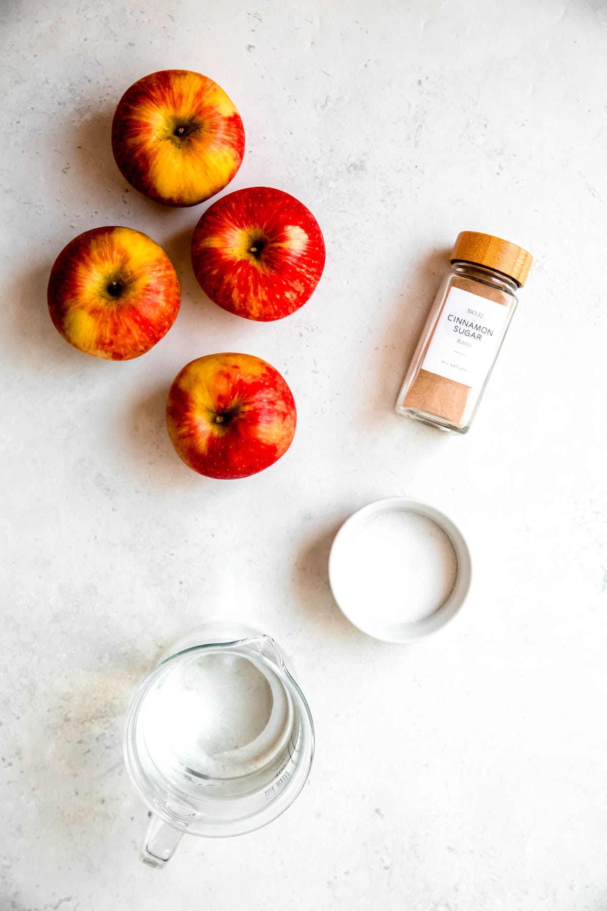 apples, water, citric acid, and cinnamon sugar measured out for making homemade apple chips.