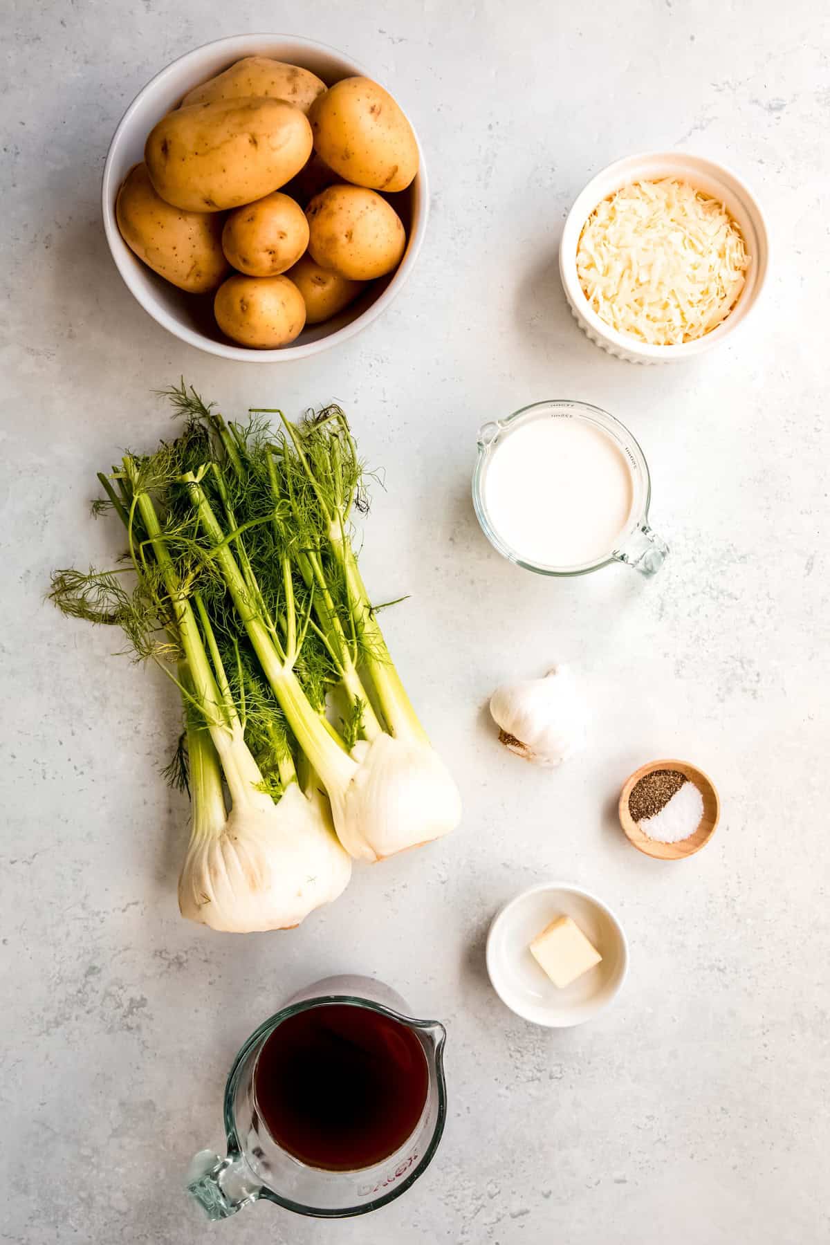ingredients needed to make fennel potato gratin recipe measured out on a white table.