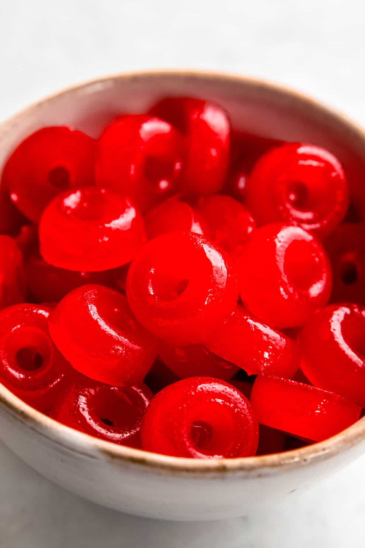 closeup shot of a bowl of homemade THC weed gummies; they're red rings.