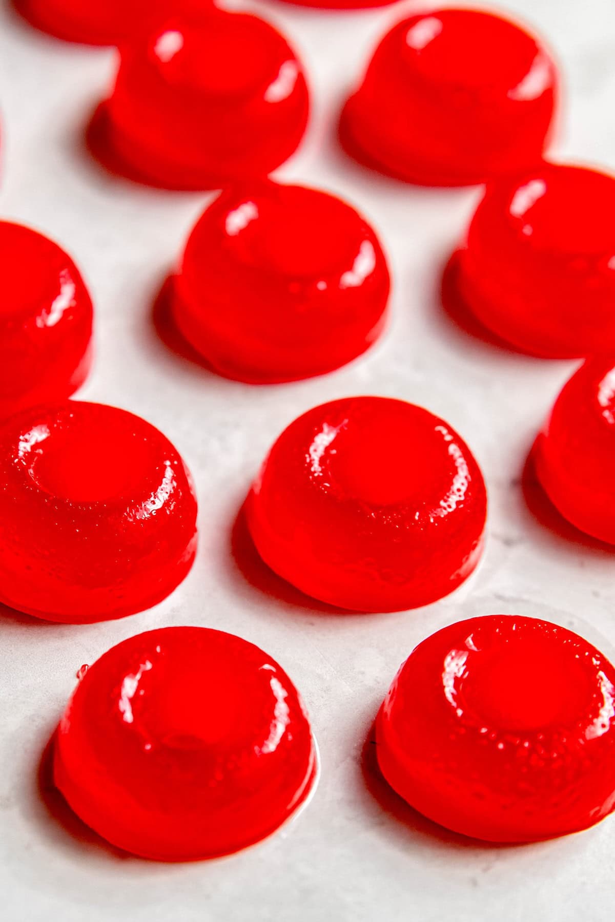 45 degree angle shot of round, red gummy rings that are homemade weed edibles after removing from the mold.