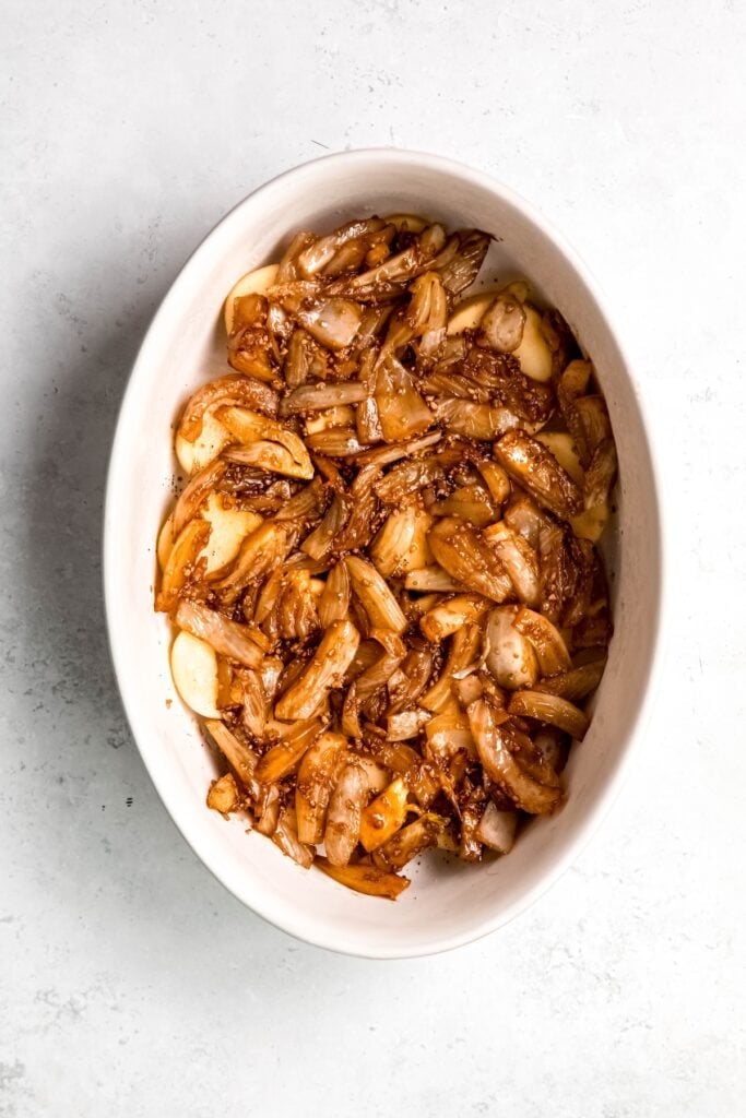 caramelized fennel spread out over the first layer of sliced potatoes.