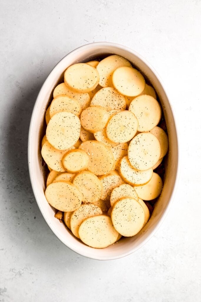second layer of sliced potatoes stacked on top of the fennel and sprinkled with salt and pepper.
