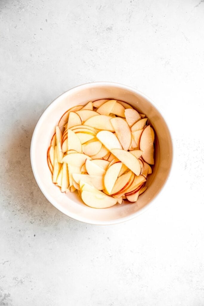 thinly sliced apples soaking in the citric acid bath.