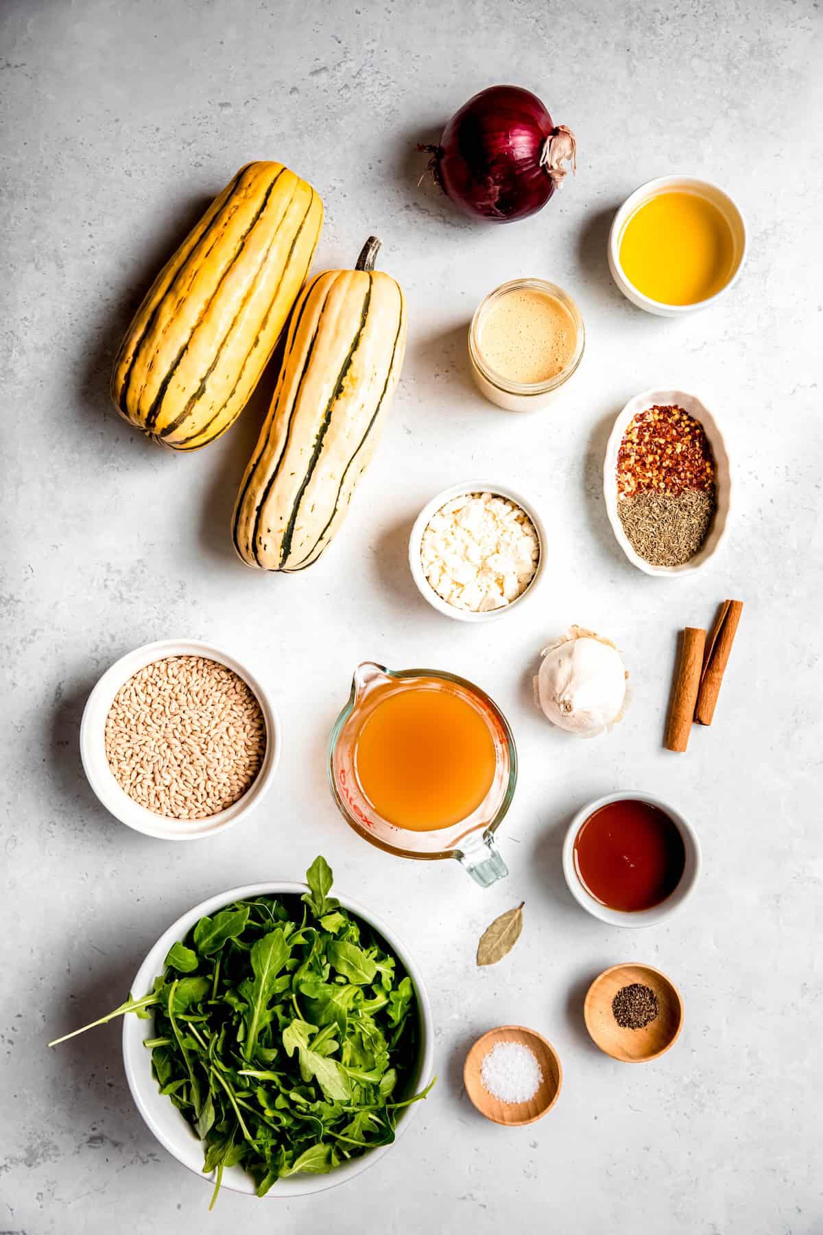 ingredients for making delicata squash salad recipe measured out on a white table.