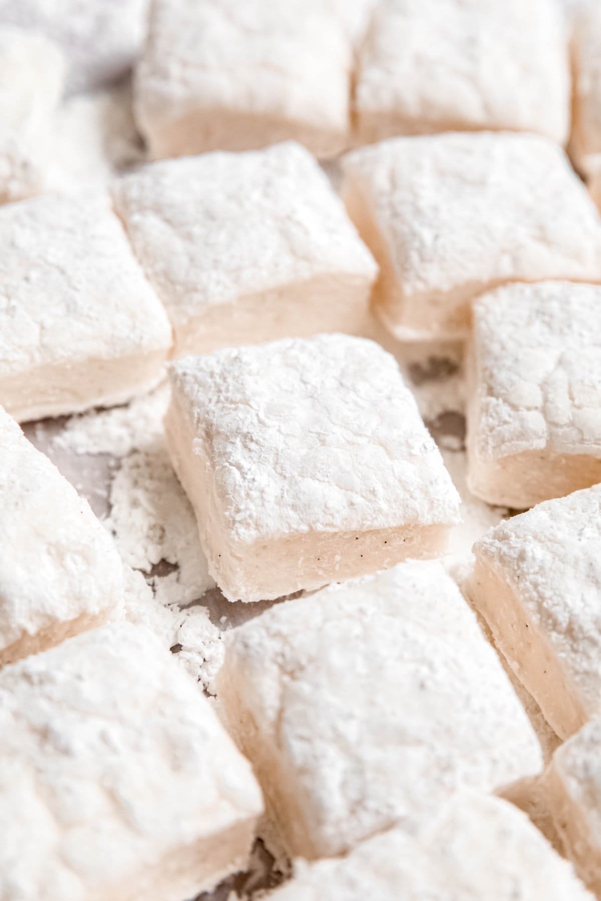 closeup shot of fluffy homemade marshmallows that have been cut into squares.