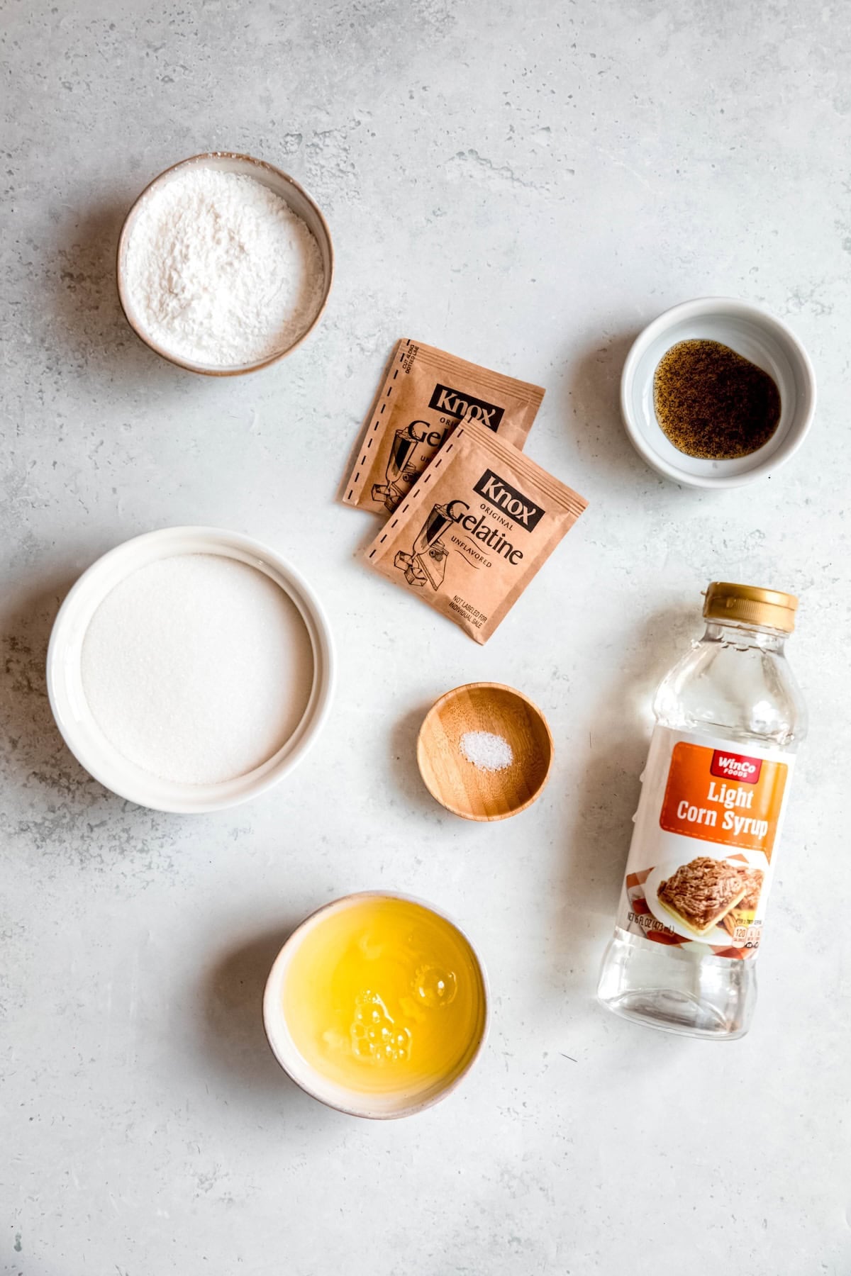 ingredients needed to make dairy-free egg white marshmallows measured out on a white table.