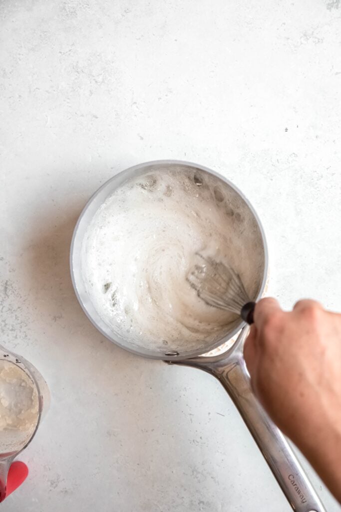 hand whisking the bloomed gelatin into the sugar mixture; it's very foamy looking.