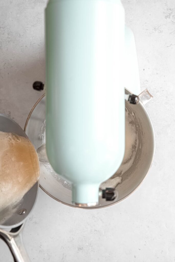 action shot of the sugar syrup being poured into the mixer with the egg whites while the mixer is running; it's running down the side of the bowl before hitting the eggs which helps cool it.