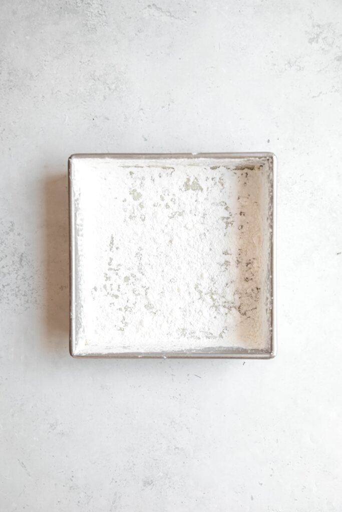 8x8 baking tin heavily coated with cornstarch and powdered sugar before pouring in the marshmallow mixture.