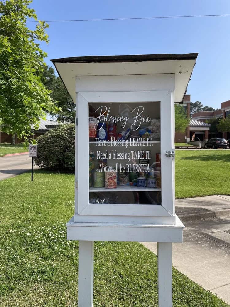rectangular white free pantry with the words "blessing box; have a blessing leave it; need a blessing take it; above all be blessed."