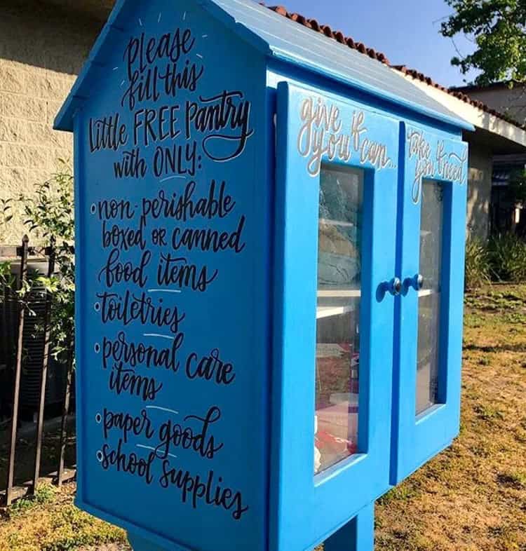 blue blessing box that reads "please fill this little free pantry with only non-perishable boxed or canned food items, toiletries, personal care items, paper goods, school supplies" on the side and "give if you can, take if you need" on the front doors.