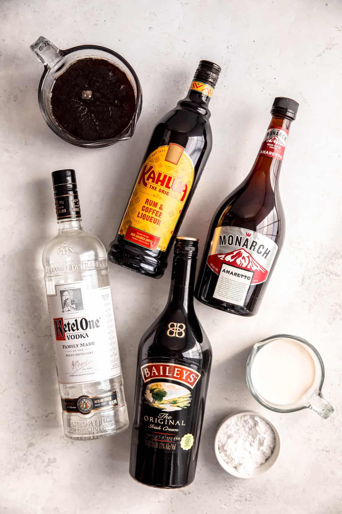 ingredients needed to make boozy christmas coffee recipe with amaretto whipped cream on a white table.
