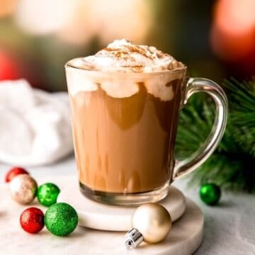 square hero image of a festive christmas coffee topped with amaretto whipped cream and cinnamon.