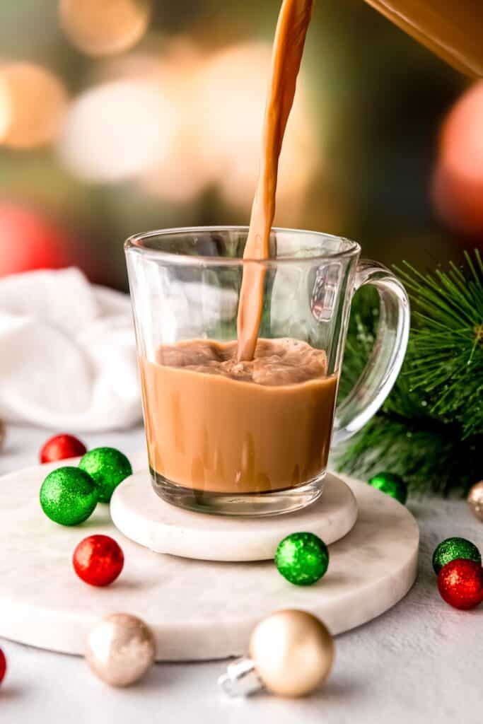action shot of the boozy christmas coffee being poured into a warmed glass mug.