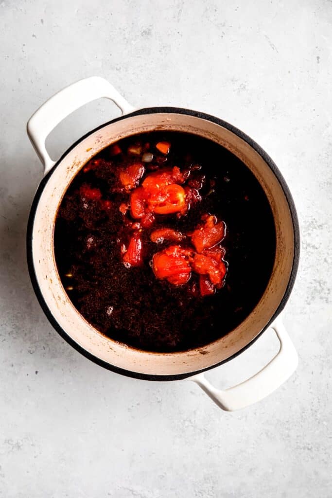 wine and canned tomatoes added to the dutch oven.