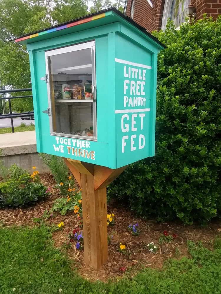 turquoise box set up as a blessings box with "little free pantry, get fed" on the side and "together we thrive" on the front.