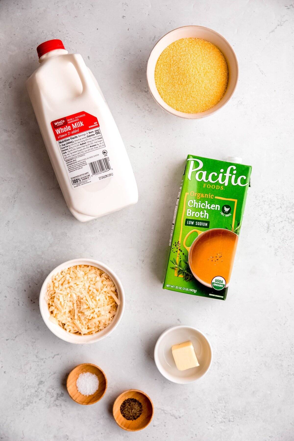 ingredients needed to make parmesan polenta recipe measured out on a white table.