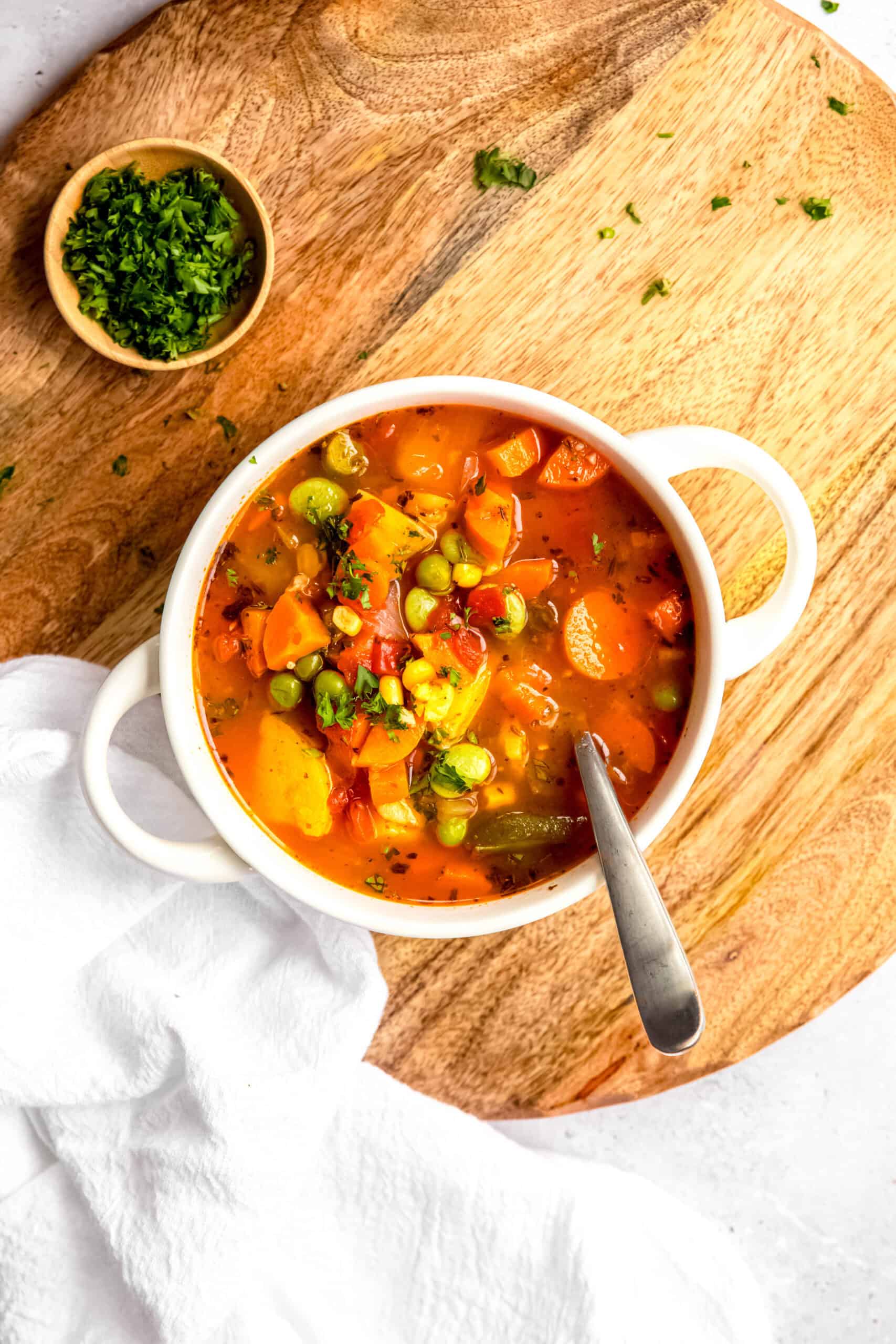 overhead shot of a bowl of IP vegetable soup with a silver spoon in it.