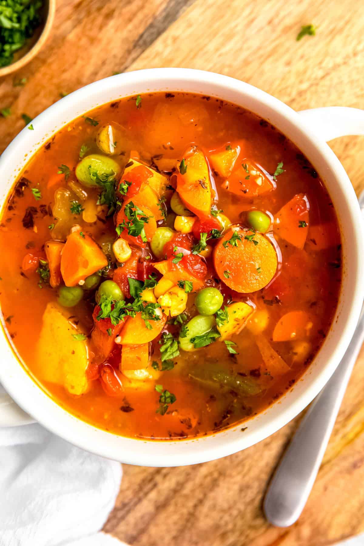 closeup overhead shot of instapot veggie soup made with frozen vegetables garnished with fresh parsley.