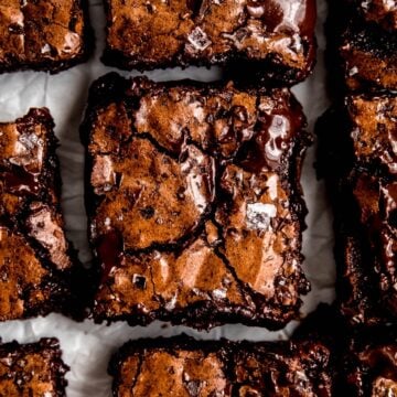 closeup overhead square hero image of double dark chocolate brownies showing their crinkly, shiny tops and fudgy edges.
