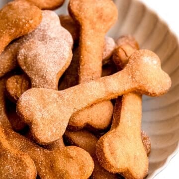 bowl of easy banana peanut butter homemade dog treats shaped like bones.