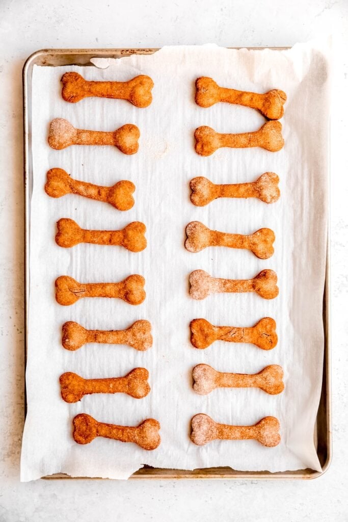 baked peanut butter banana dog treats on a parchment lined baking sheet.