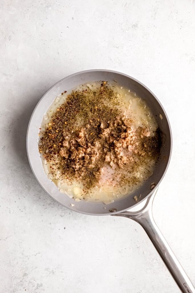clams, clam juice, and seasonings added to the skillet with the white wine onions.