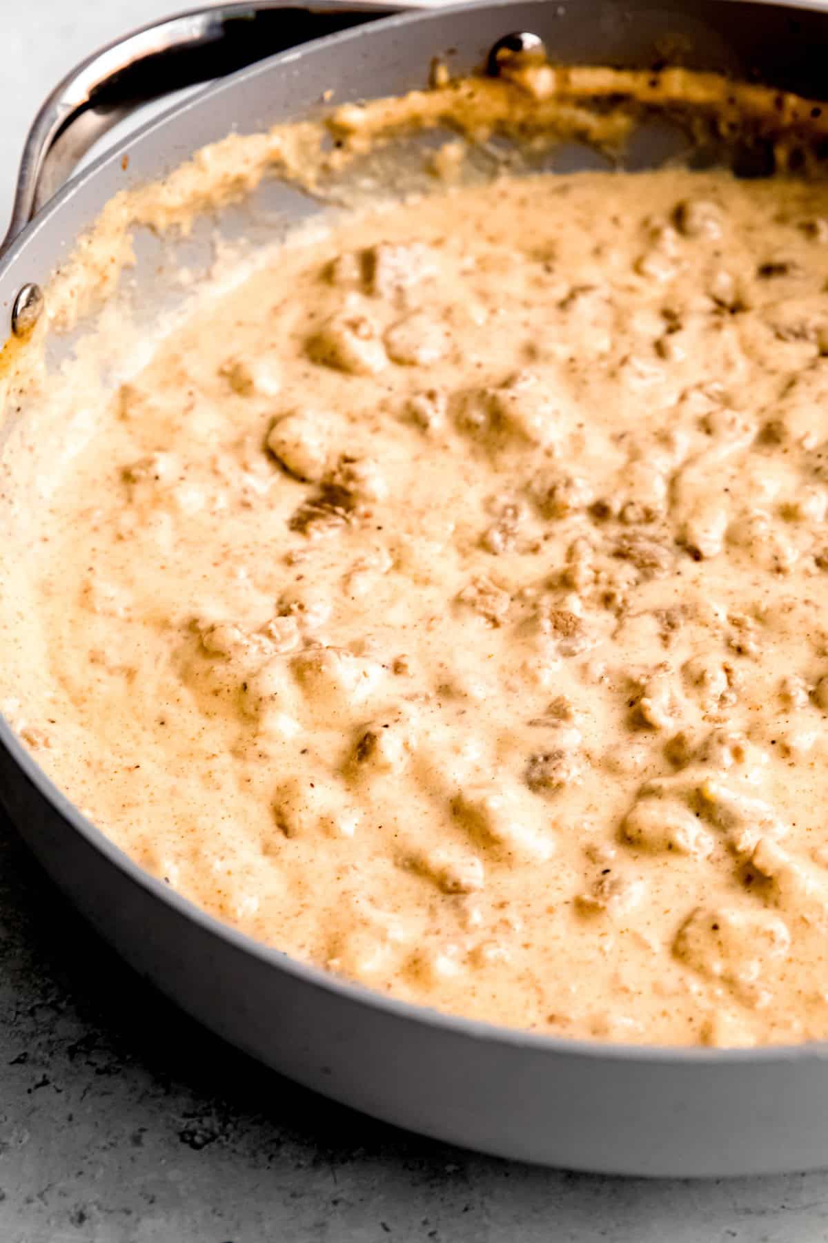 45 degree angle shot of southern sausage gravy in a skillet after simmering until thick.