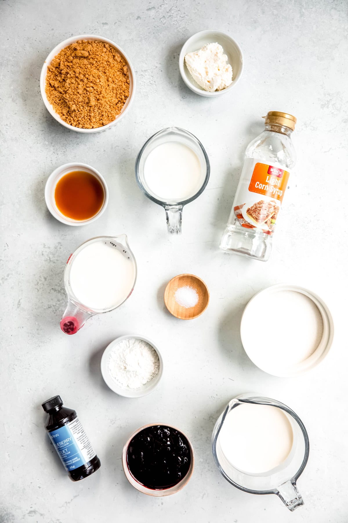 ingredients needed to make blueberry cheesecake ice cream recipe measured out on a white table.