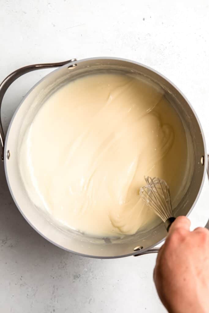 hand whisking the thickened cheesecake ice cream base after adding the slurry.