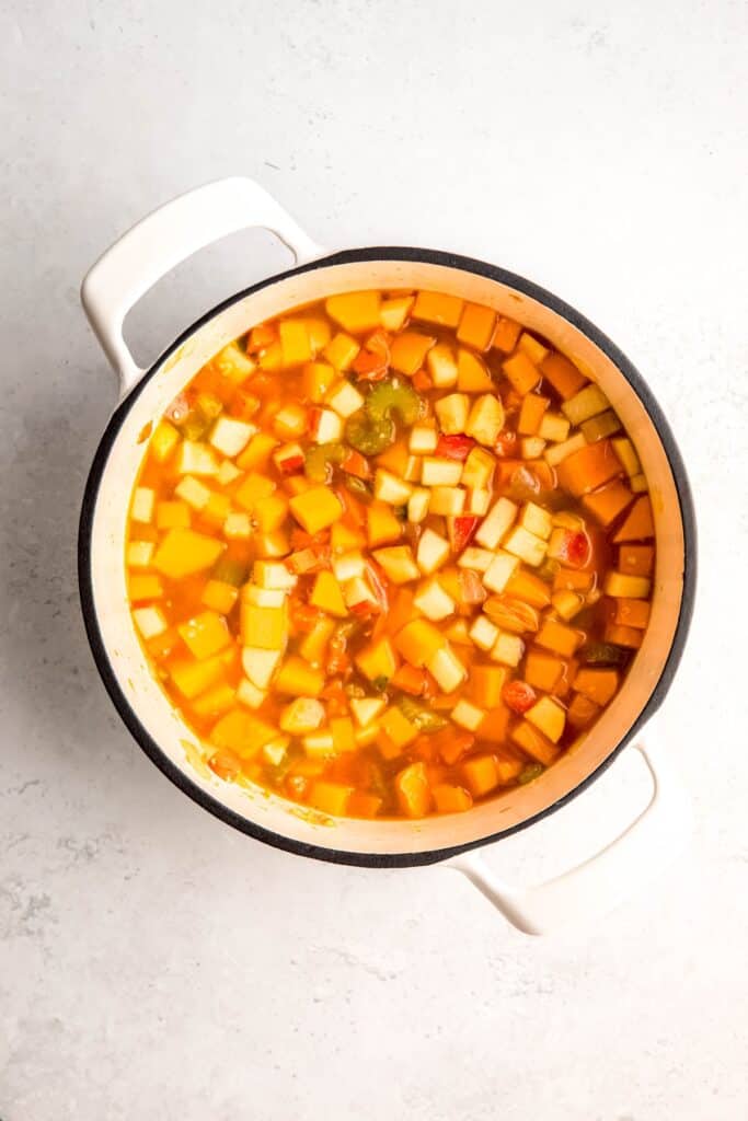 broth added to the sautéed veggies and apples for simmering.