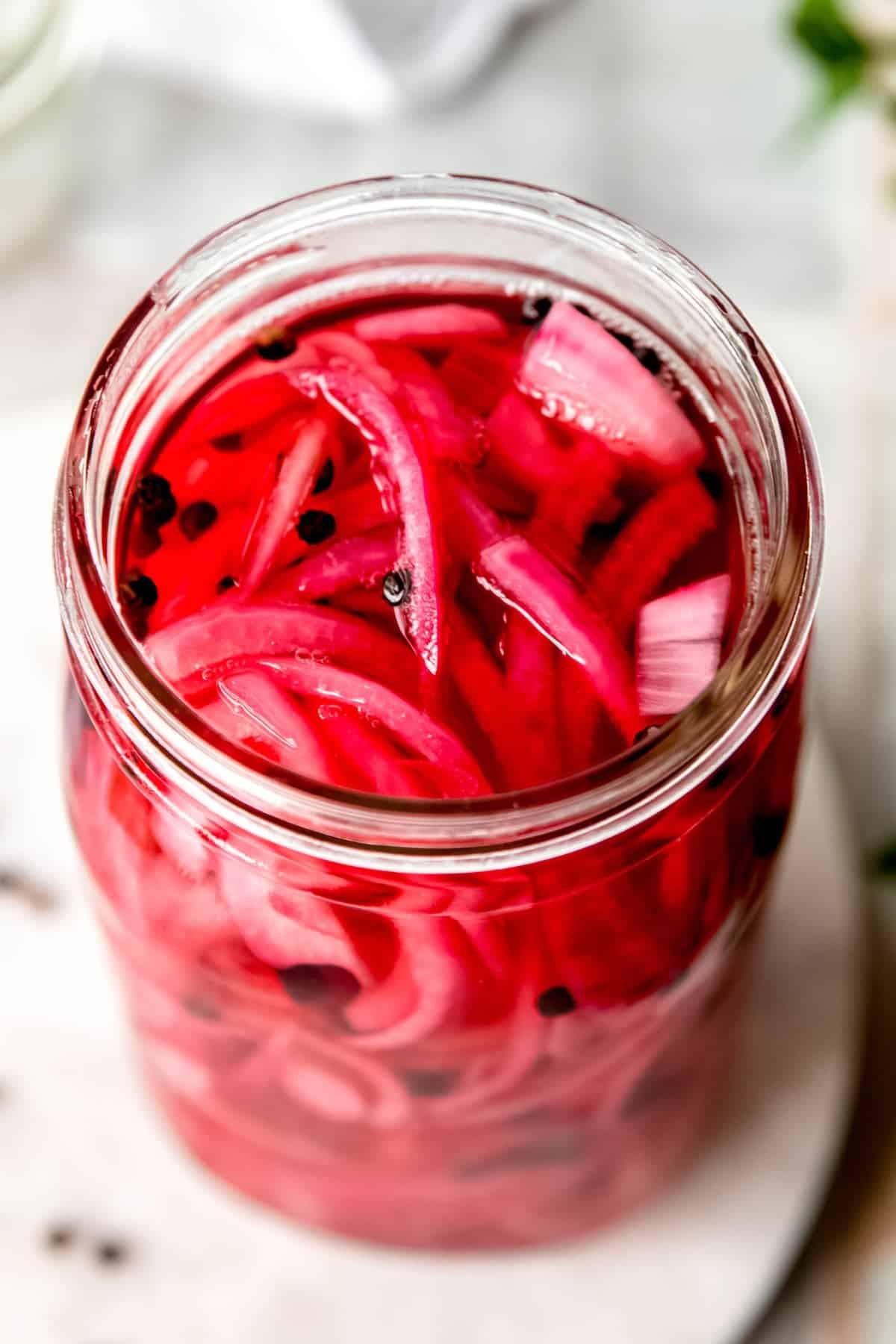 45 degree angle shot of a jar of pickled red onions.