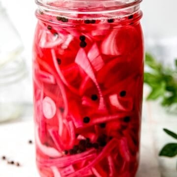 side on view of a mason jar of pickled red onions for tacos and more!