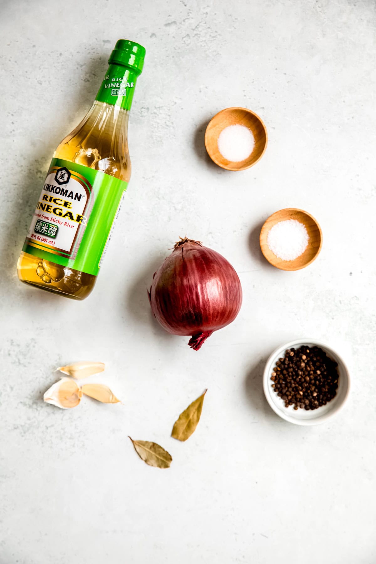 ingredients needed to make quick pickled red onions measured out on a white table.