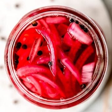 square hero image of quick pickled red onions in a jar.