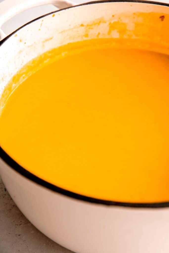 puréed spicy butternut squash apple soup in the white dutch oven.