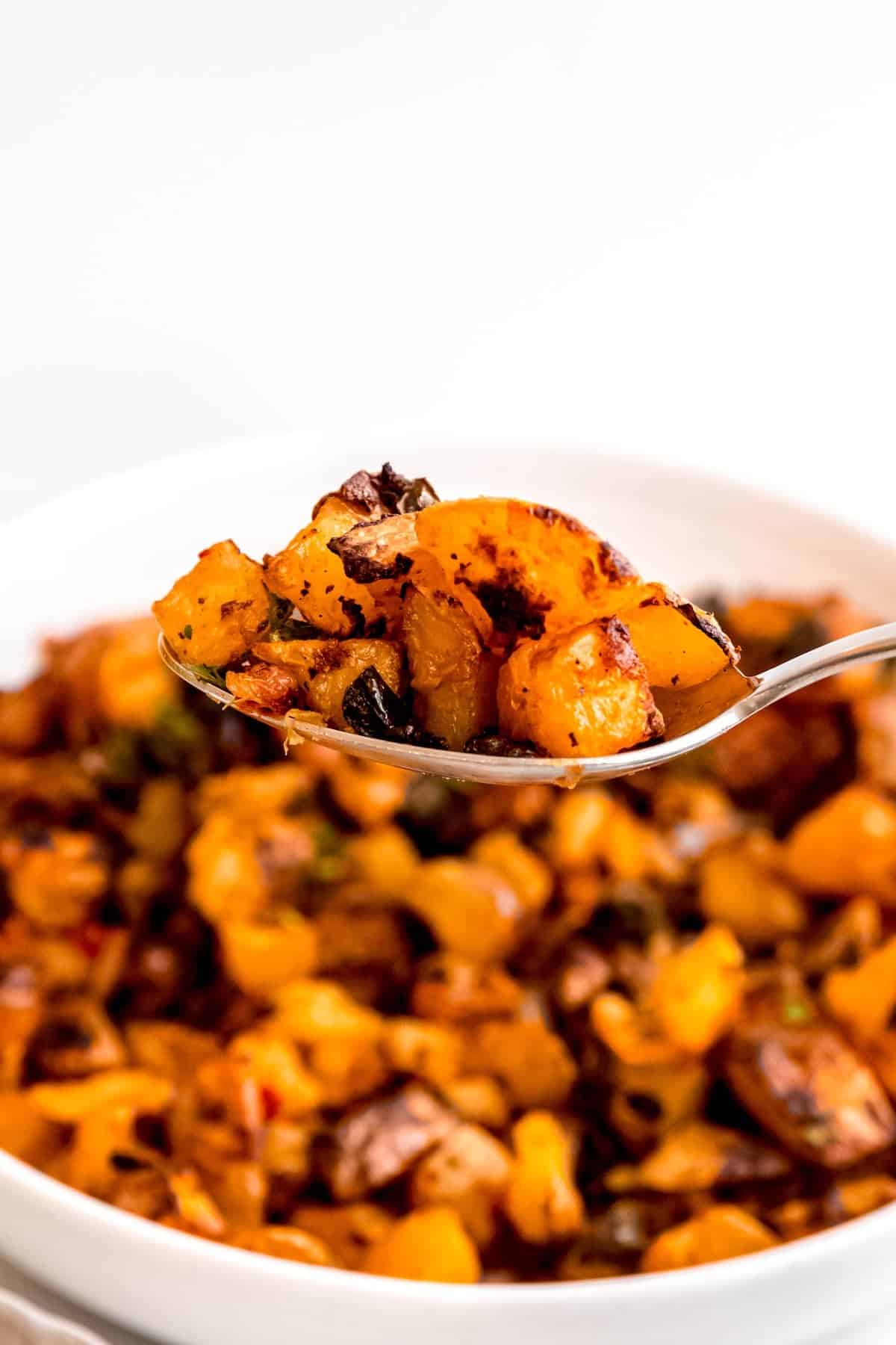silver spoon taking a scoop from a bowl of easy home fries.